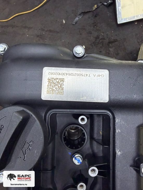 Шильдик на клапанной крышке: код G4FA и номер агрегата с QR — тот же номер, что в паспорте из коробки